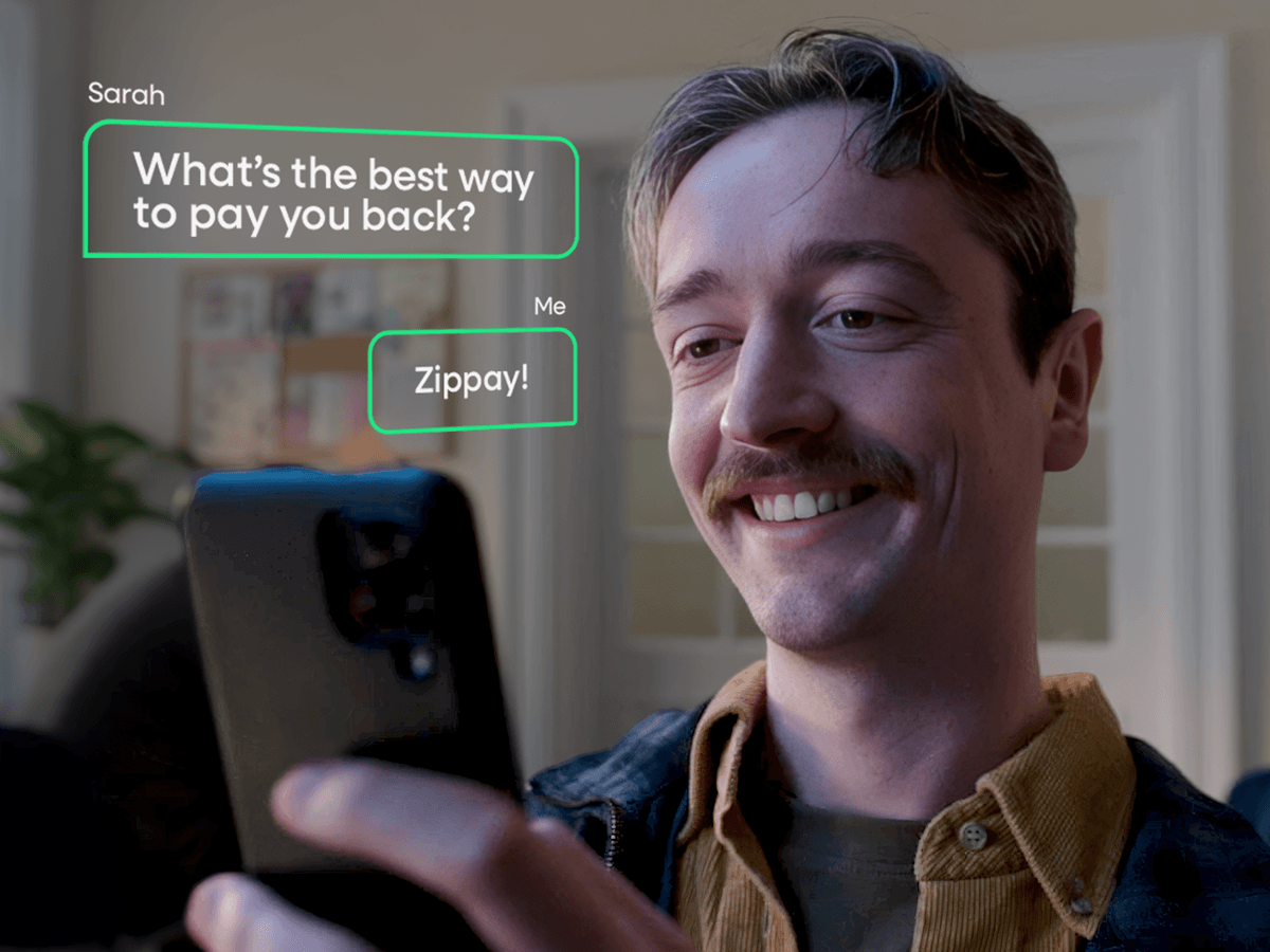 A man looking into a smartphone with text bubbles beside him that read "What