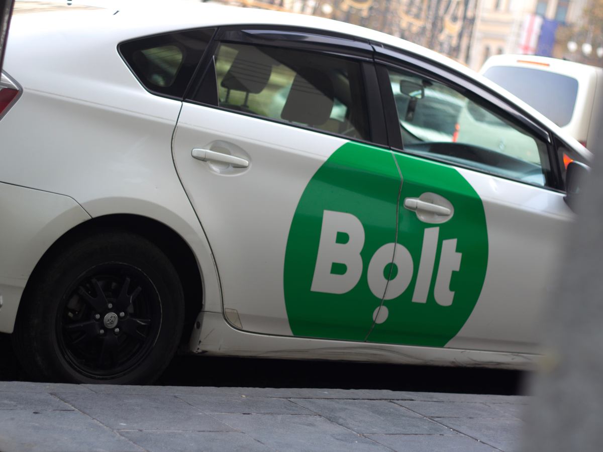 White taxi with Bolt logo in green lozenge.