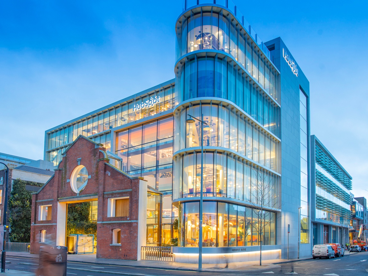 a modern glass building with warm yellow light emitting from it.