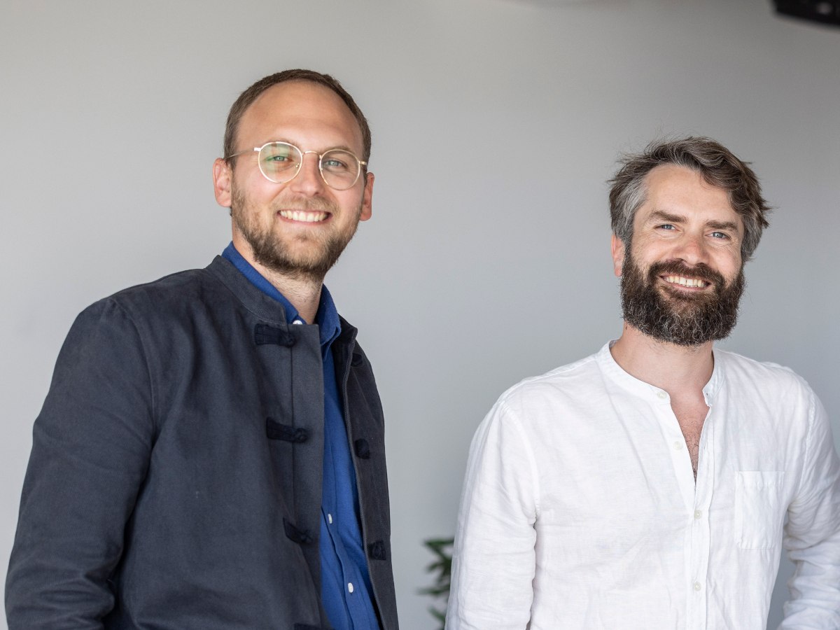 Two men standing, smiling at the camera. The picture is cut at the bust.