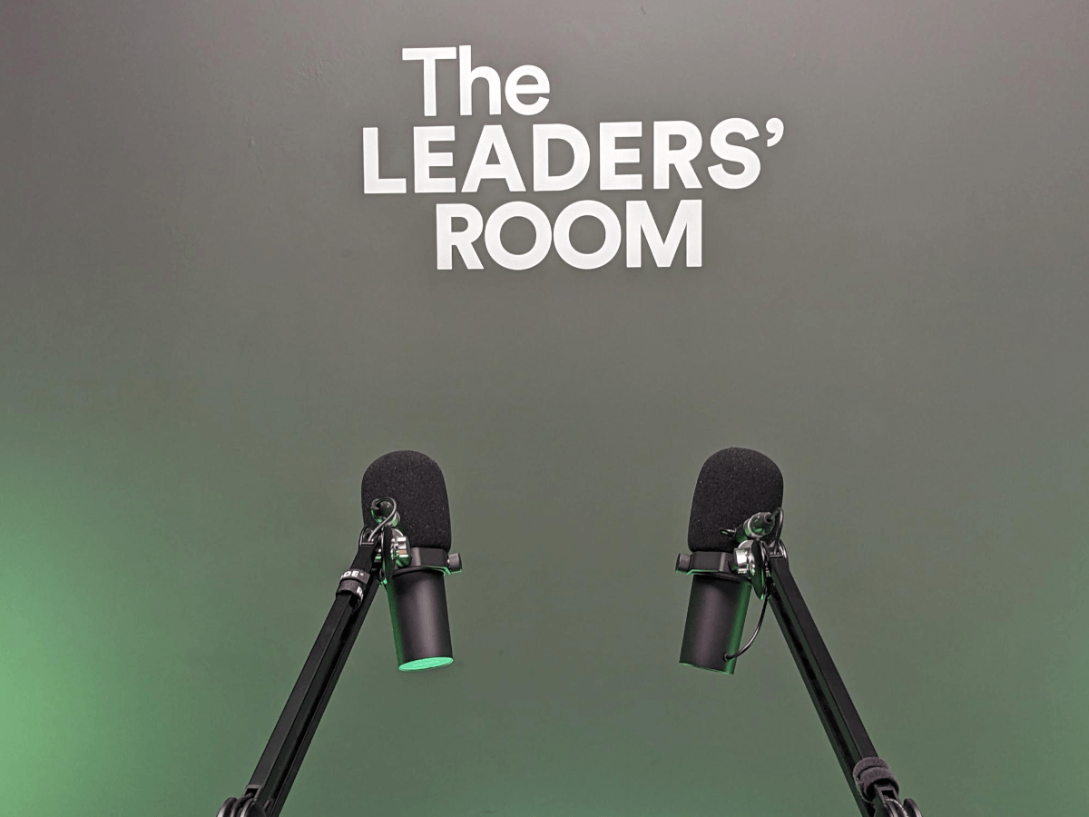 Two podcast microphones and The Leaders Room logo.