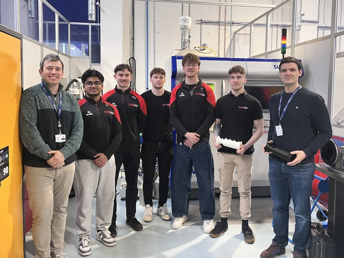 Seven men on the ULAS HiPR team posing in a line and holding scaled down rocket models.