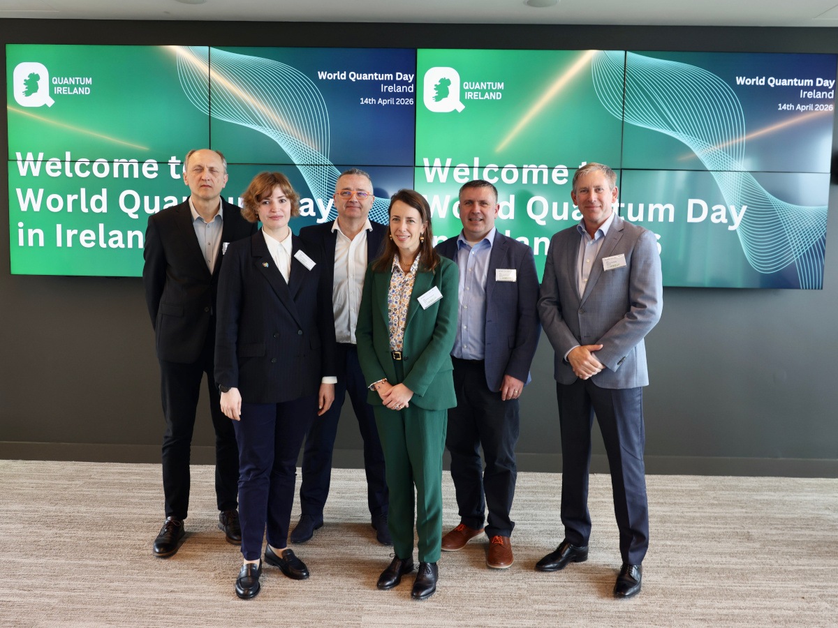 six middle aged business people in front of an Equal1 and Bull branded sign.