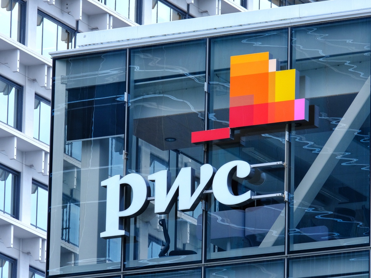 The PwC logo against a glass building