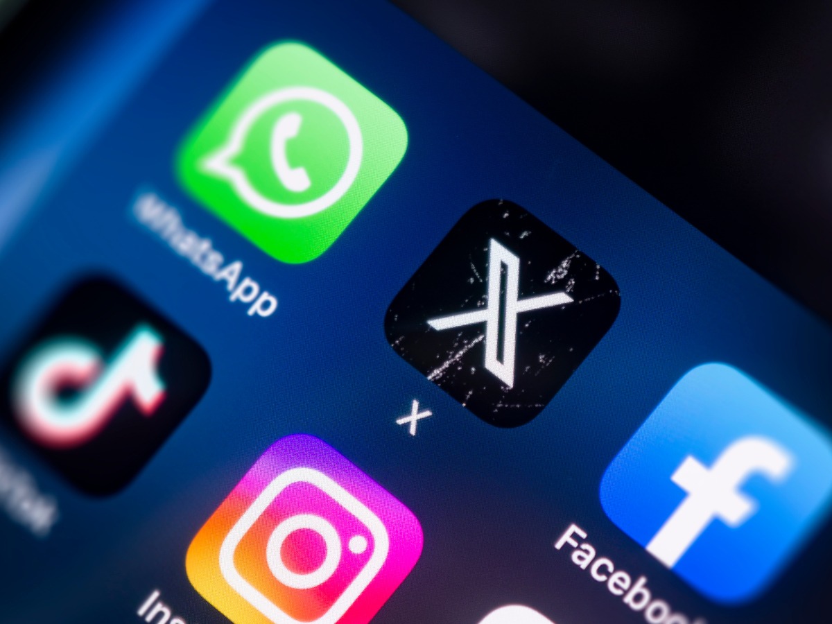 The X app icon on a phone screen, alongside other social media app icons.