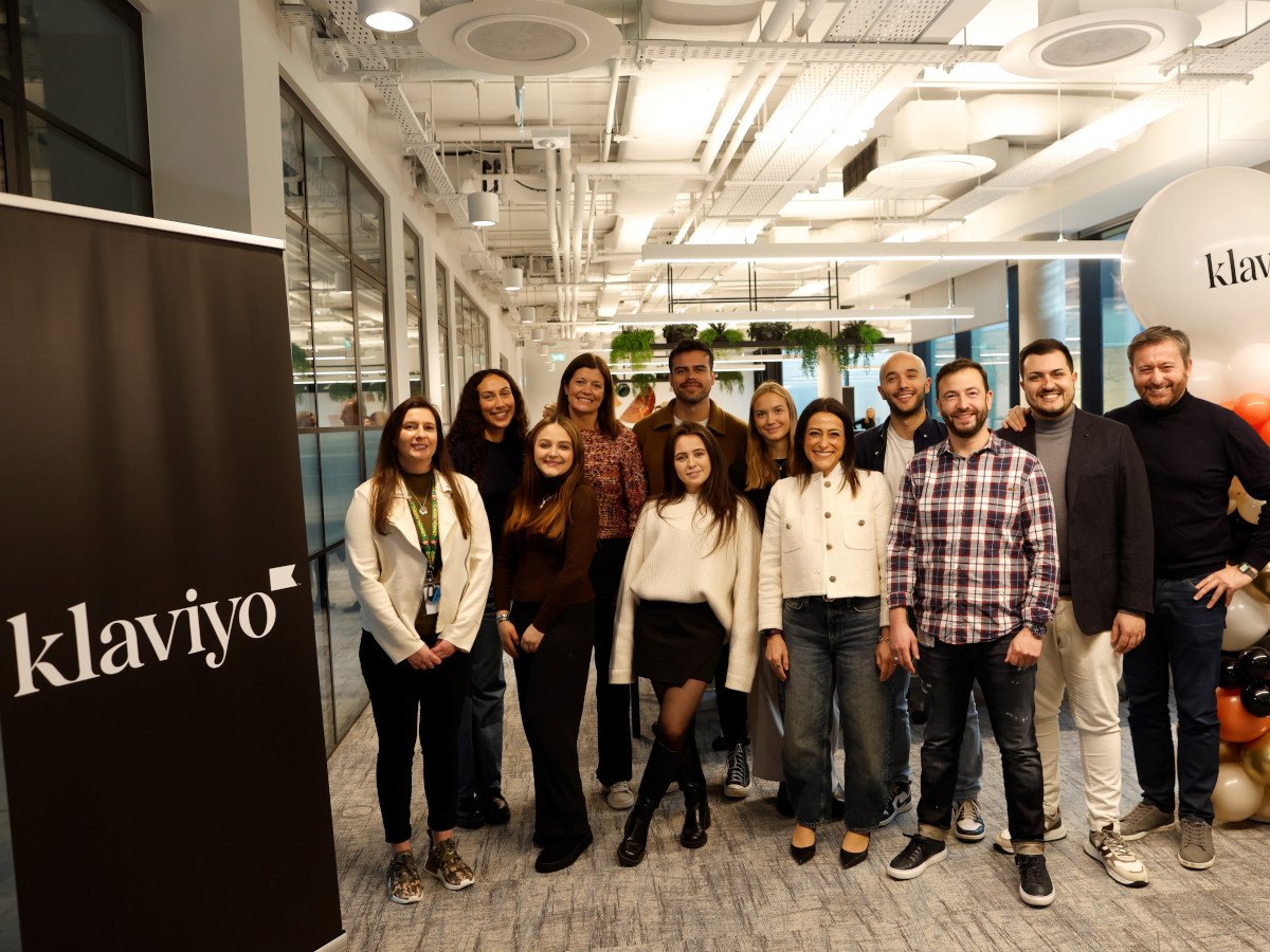 A diverse group of co-workers from Klaviyo posing in an office