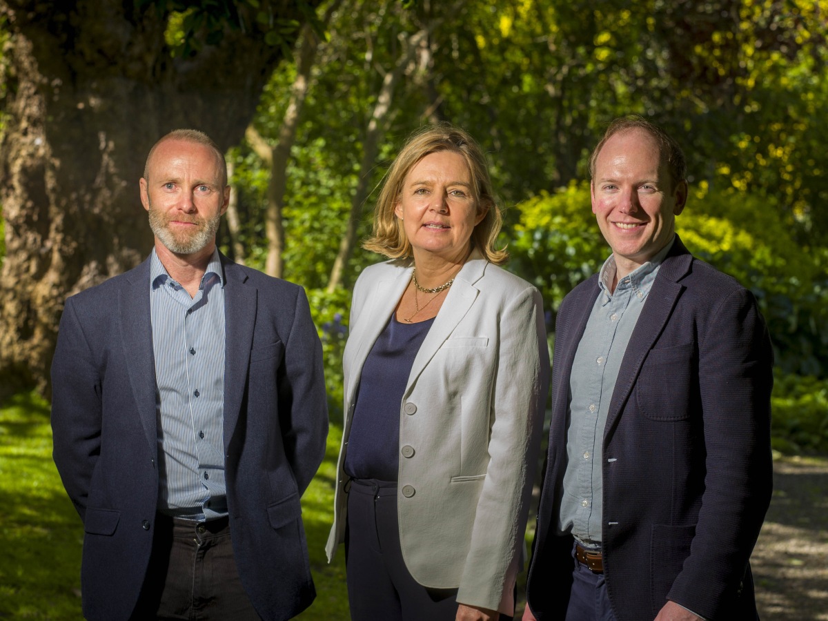 Two men and one woman with external park-like background