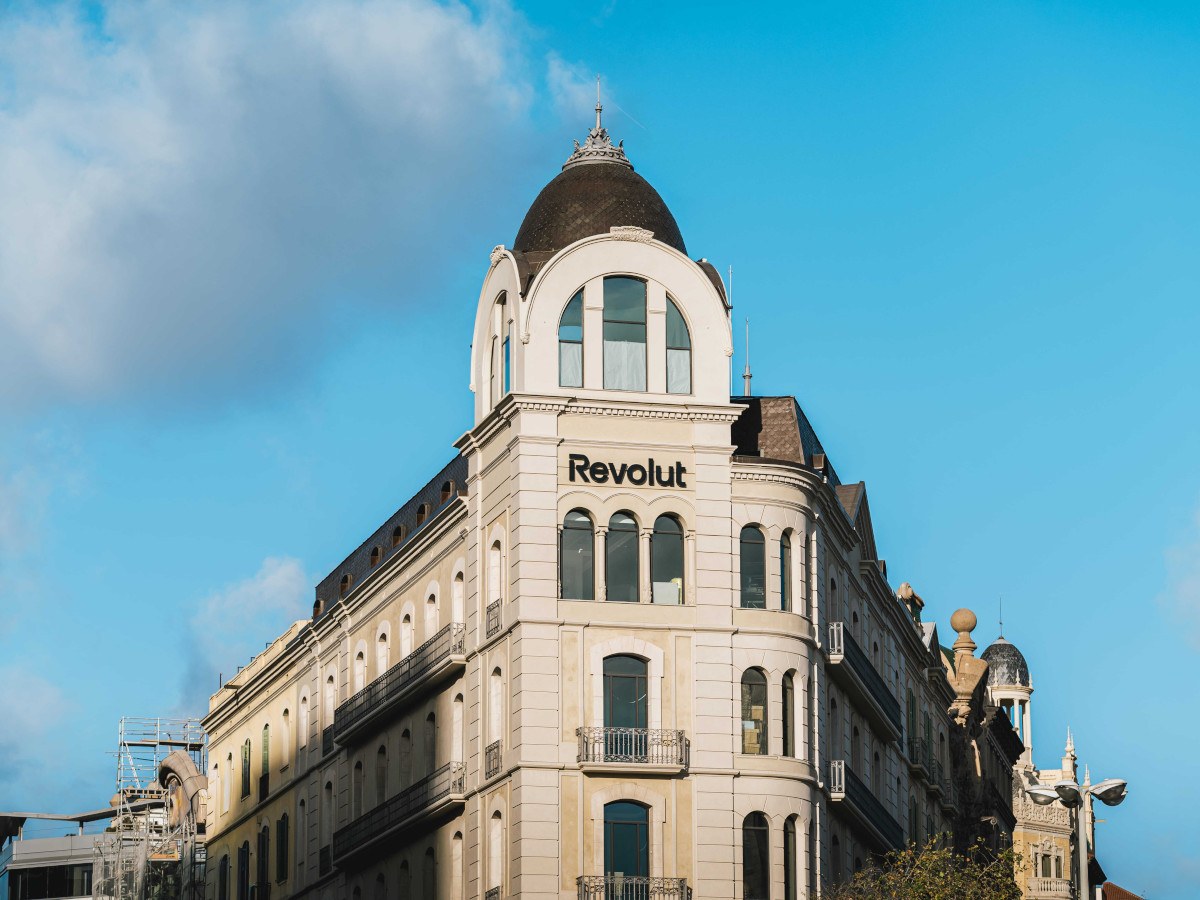 Clear blue sky with some clouds to the left. A tall building with a domed top.