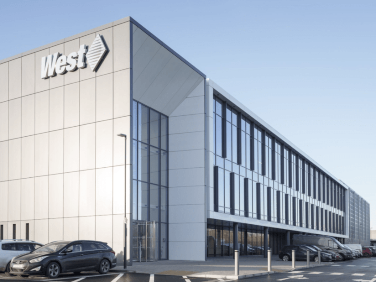 A grey building with the West Pharmaceutical logo, against a blue sky.