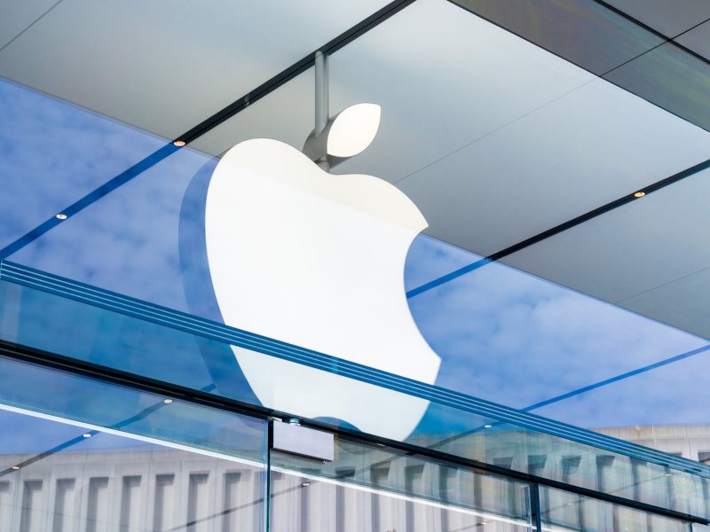 The Apple logo on the window of a building.