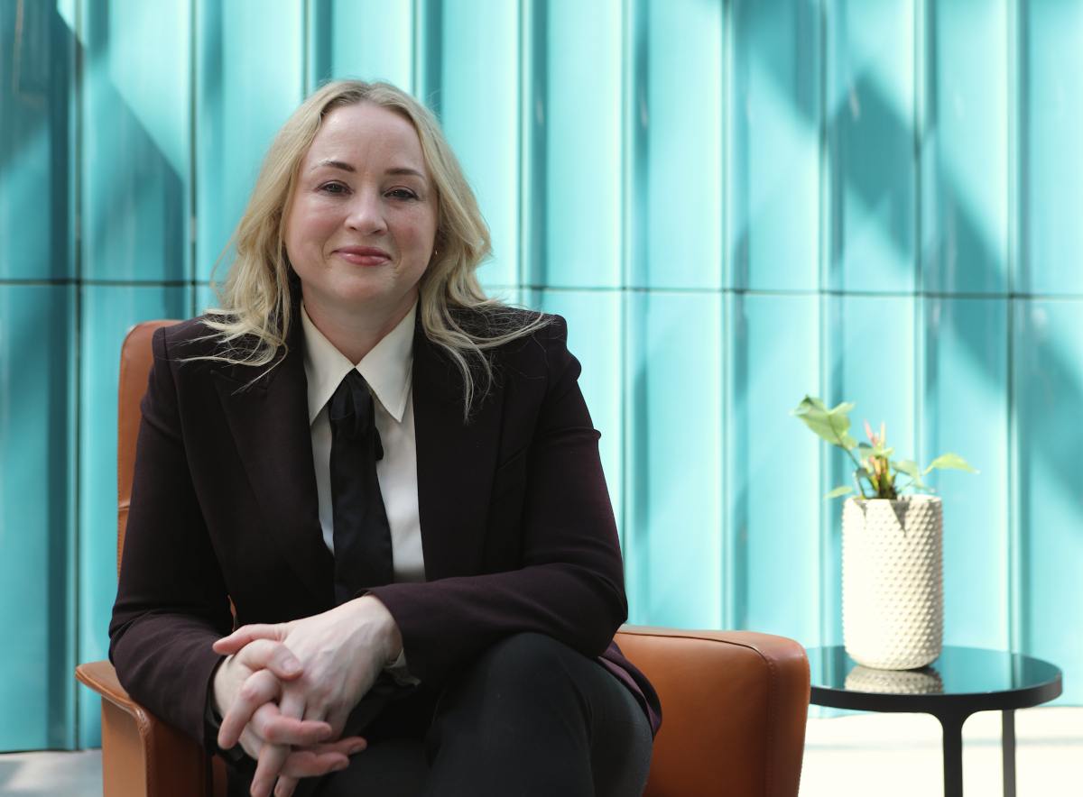 blonde woman in short and tie seated