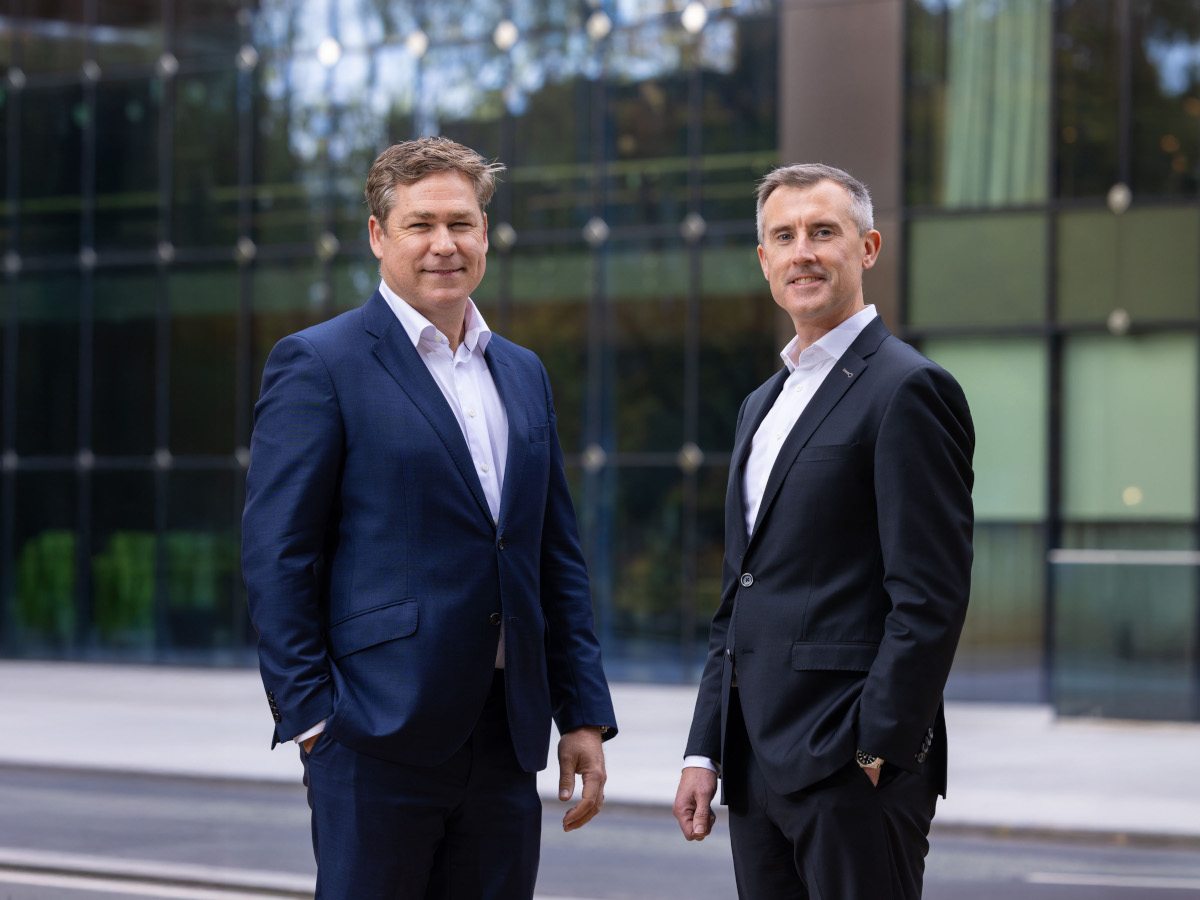 Two men in suits standing next to each other.