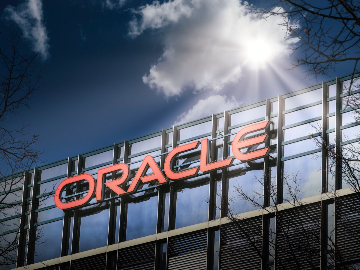 A glass building with the Oracle logo, under sunlight.