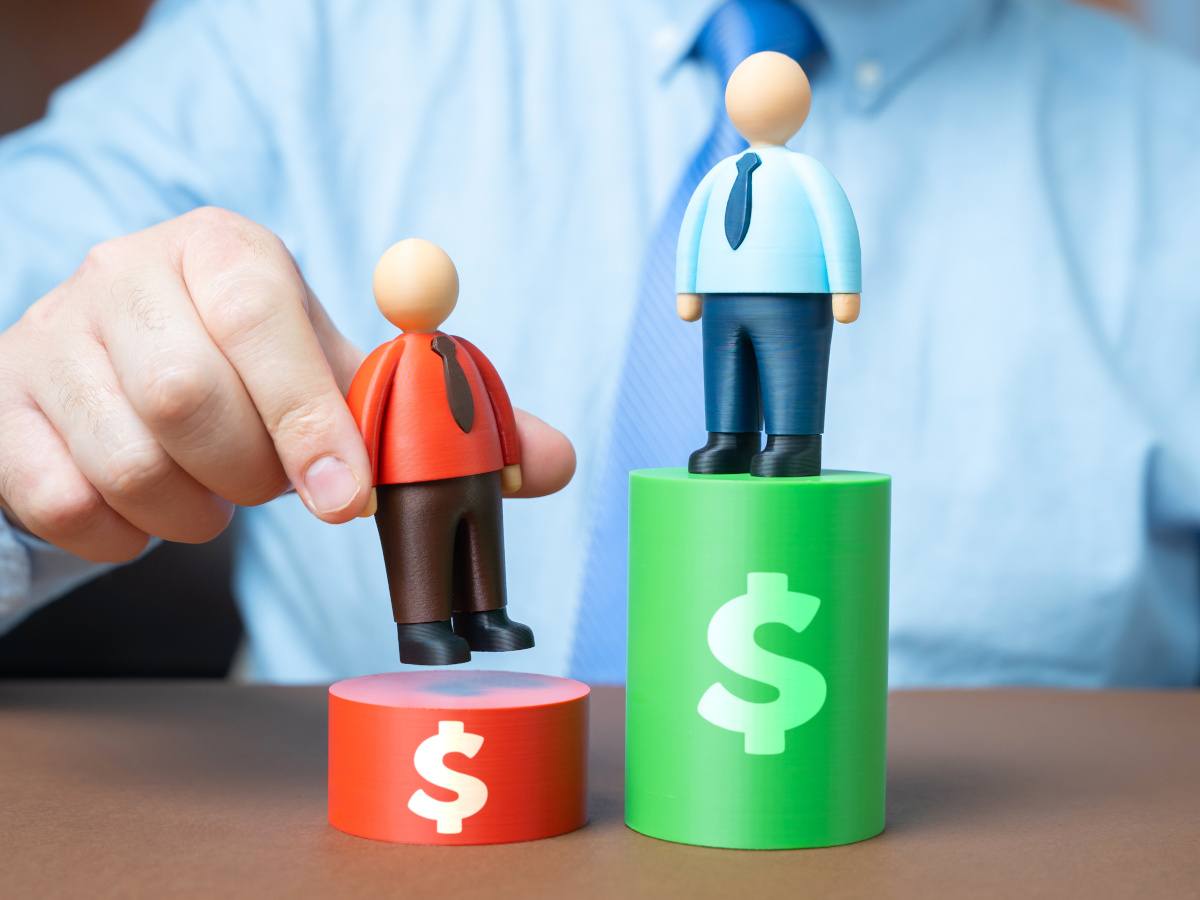 Wooden figures on pegs representing poor and stronger pay.
