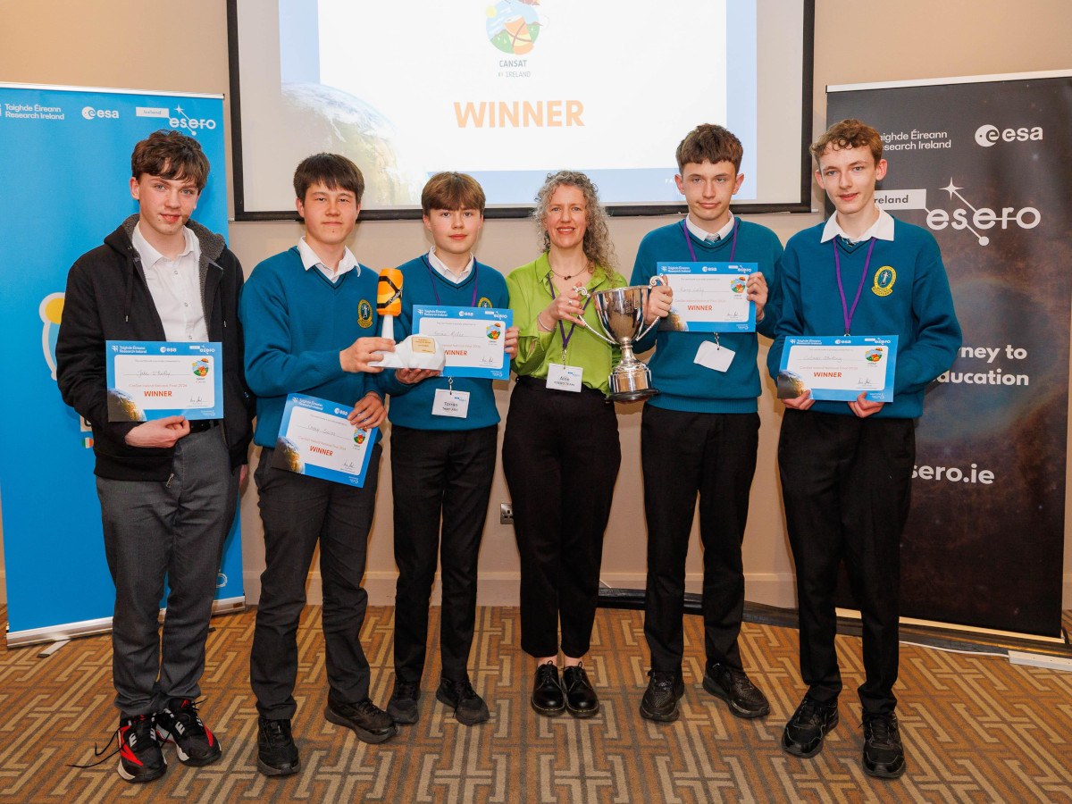 Five teenage boys in school uniforms holding ESA certificates, with a middle aged woman standing in the middle.