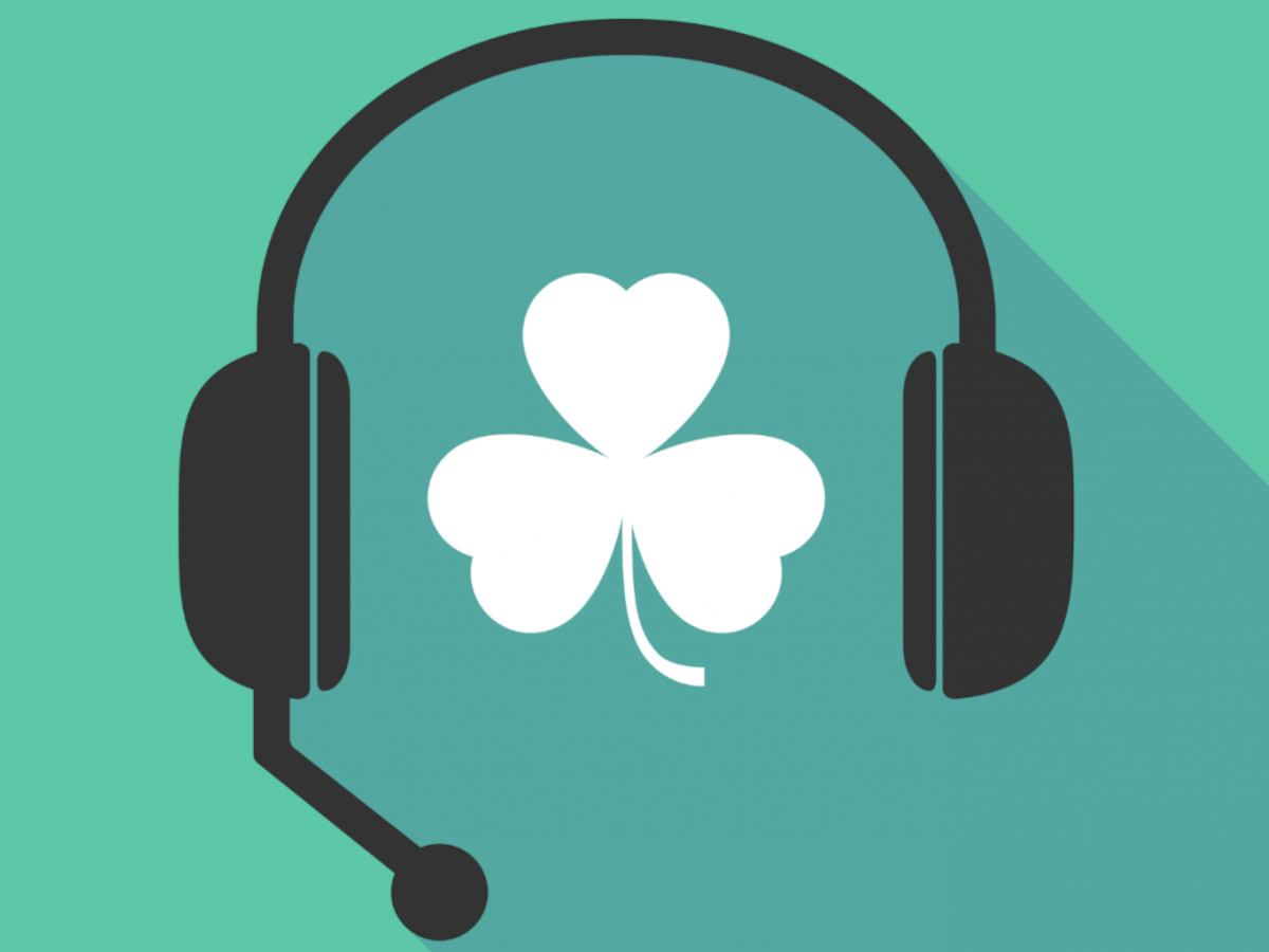 A cartoon black headset with a white shamrock at the centre against a green background.