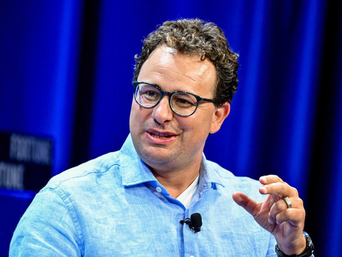 A man in a light blue shirt talking.