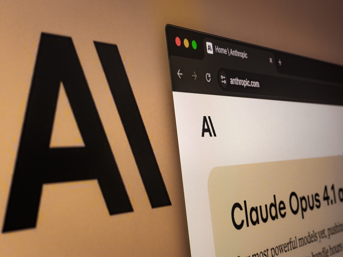 Anthropic company logo on a screen with a web page that shows Claude on its website.