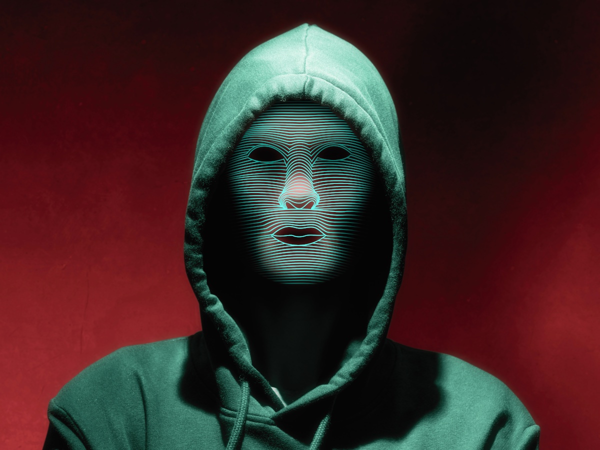 Portrait of a person in a hoodie with digital face mask.