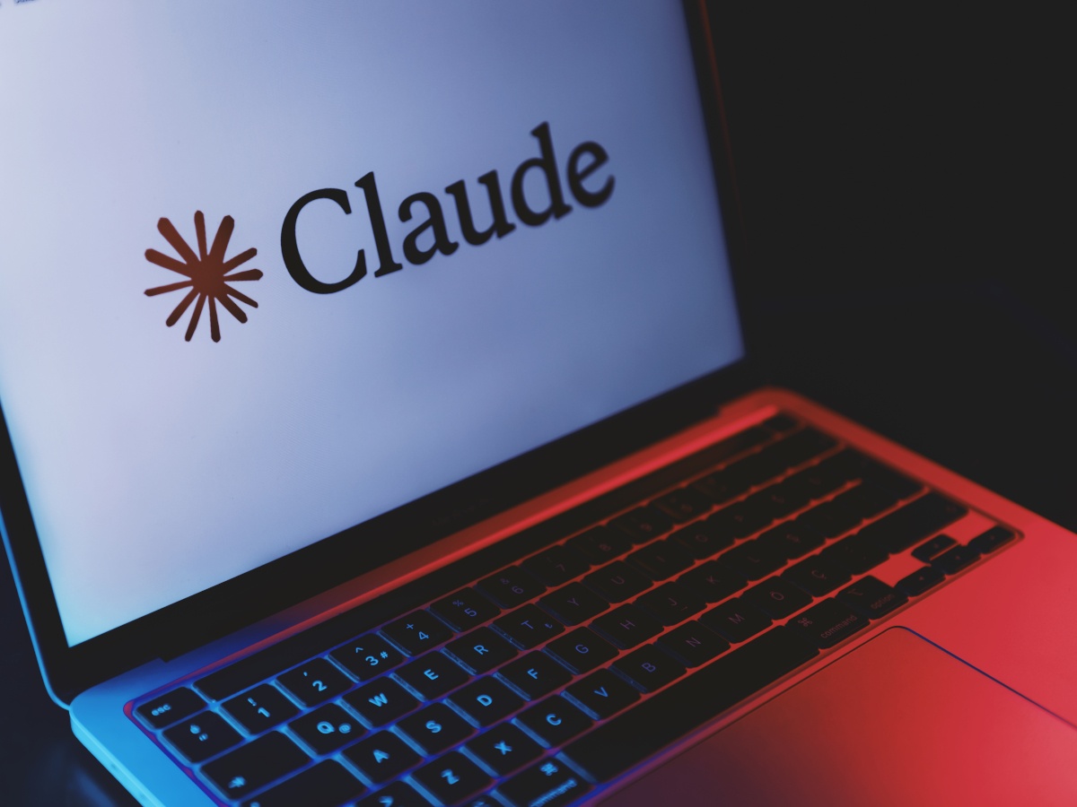 The Claude logo showing on a MacBook laptop screen.