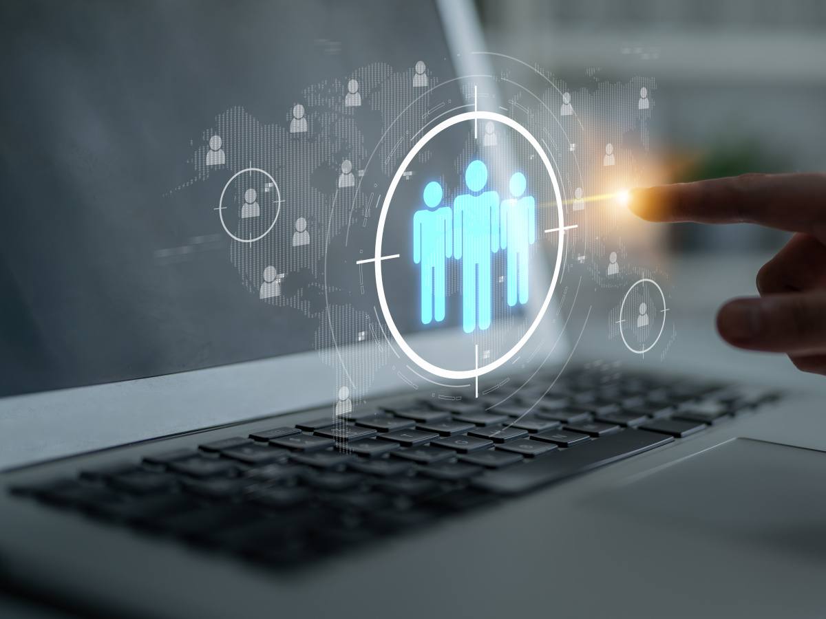 A finger pressing a 3-D image of a group of people, indicating specific group-focused research.