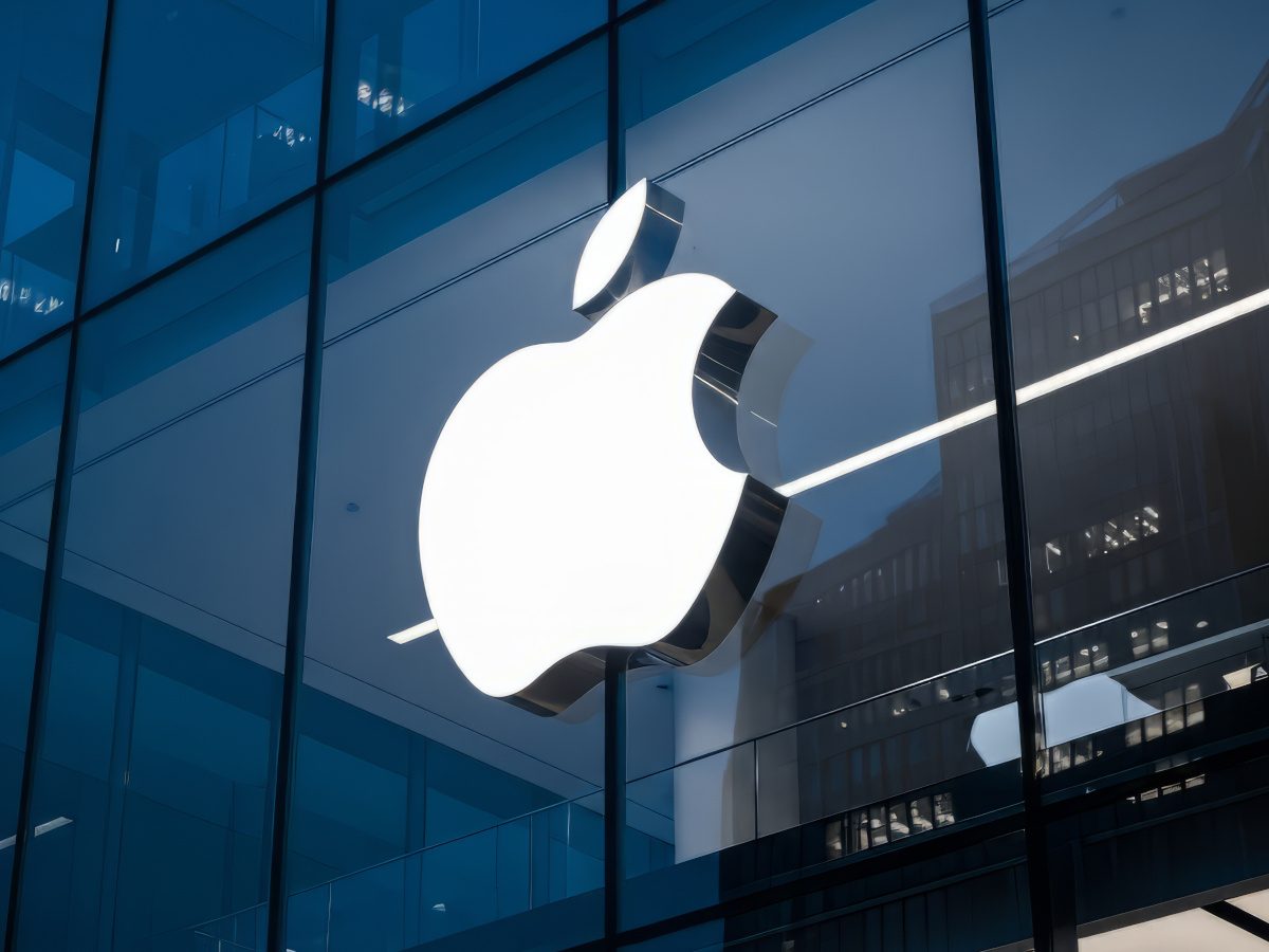 The Apple logo against a glass building.