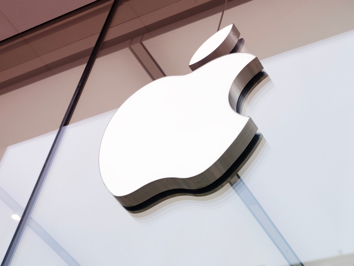 A close up of the Apple logo on a glass window.