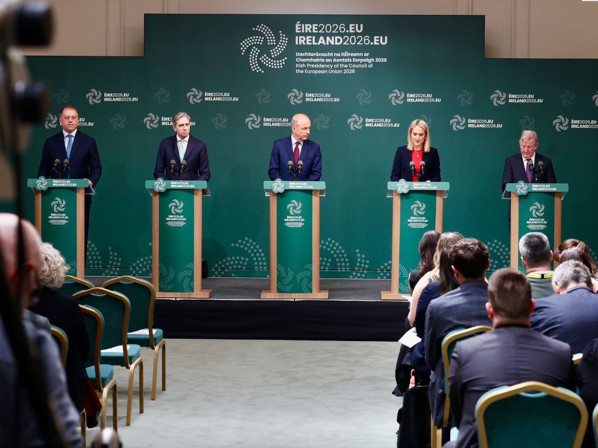 A media briefing room with five podiums where politicians are standing, speaking.