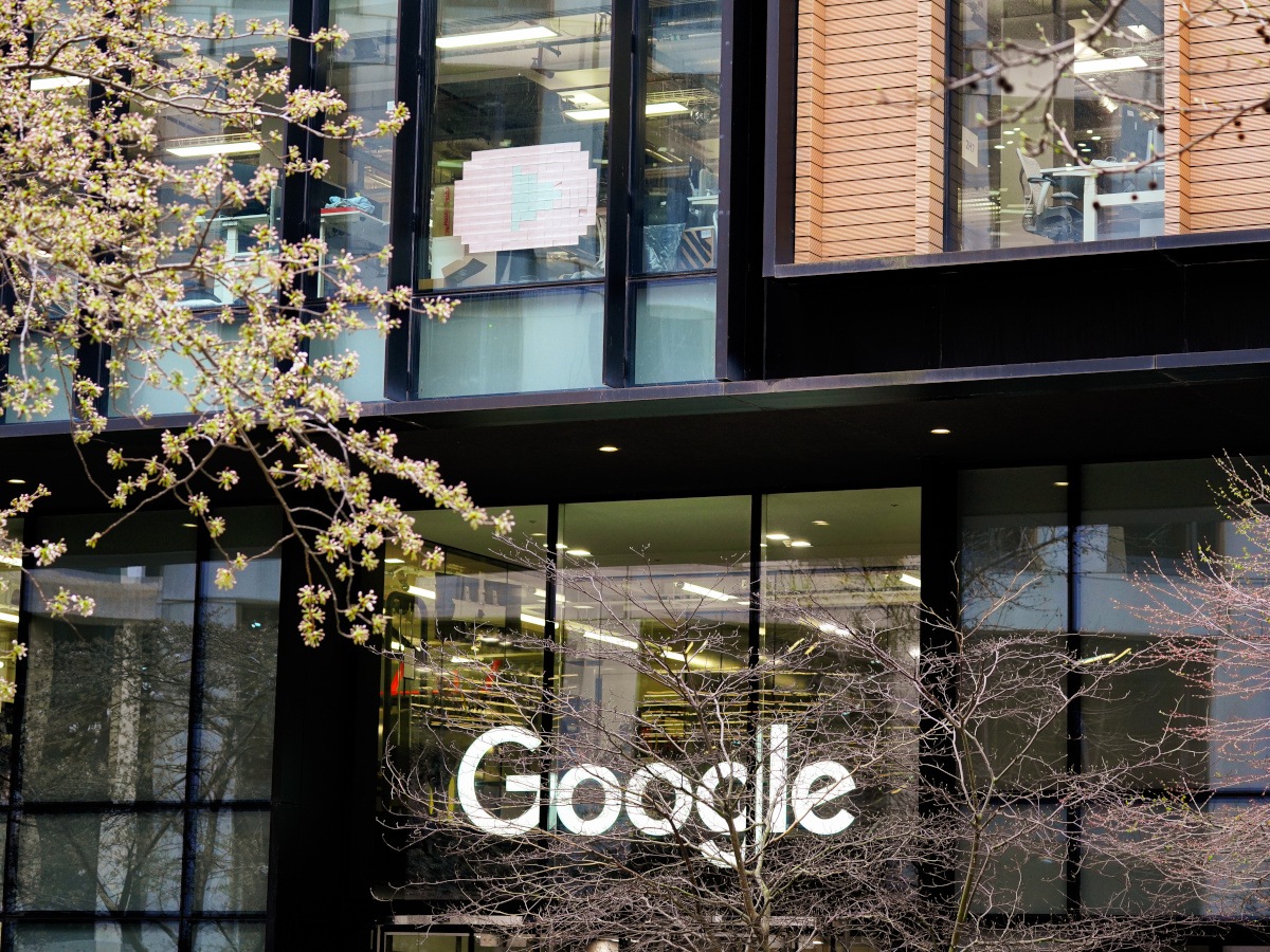 The Google logo against a stone and glass building.