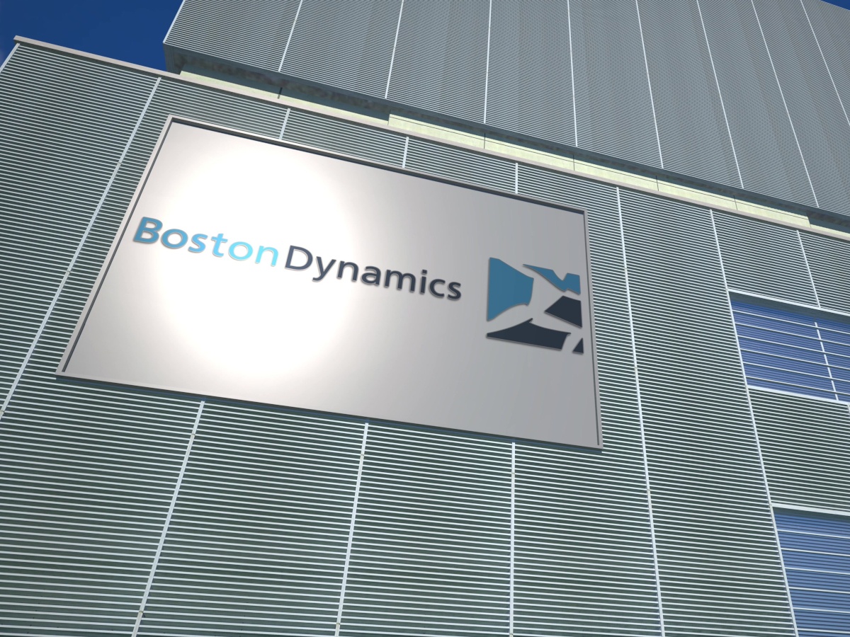 A metallic building facade with a sign displaying the Boston Dynamics logo.