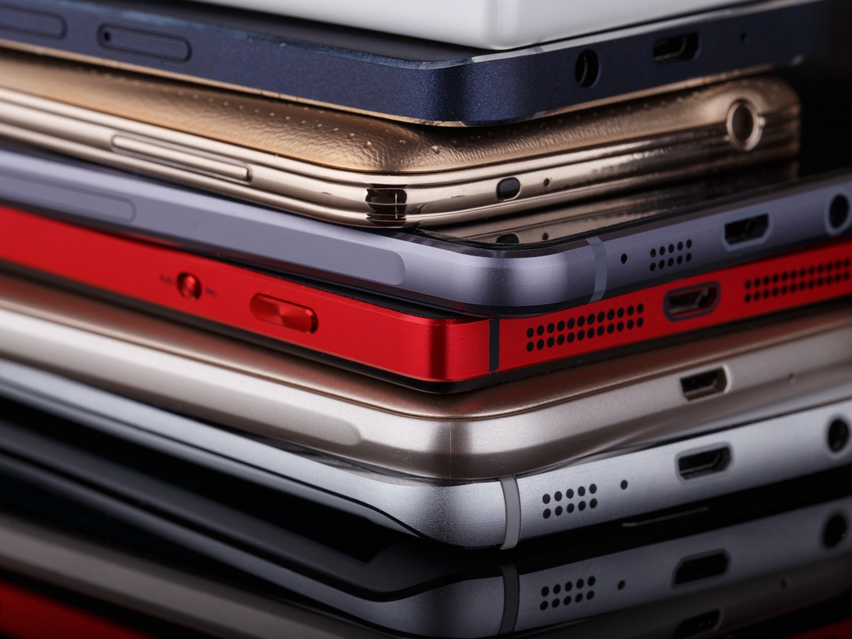 A heap of 6 smartphones stacked on top of each other.