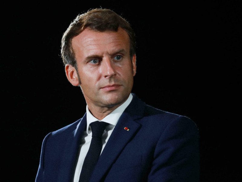A close-up image of French president Emmanuel Macron looking to his left, wearing a dark suit and white shirt.