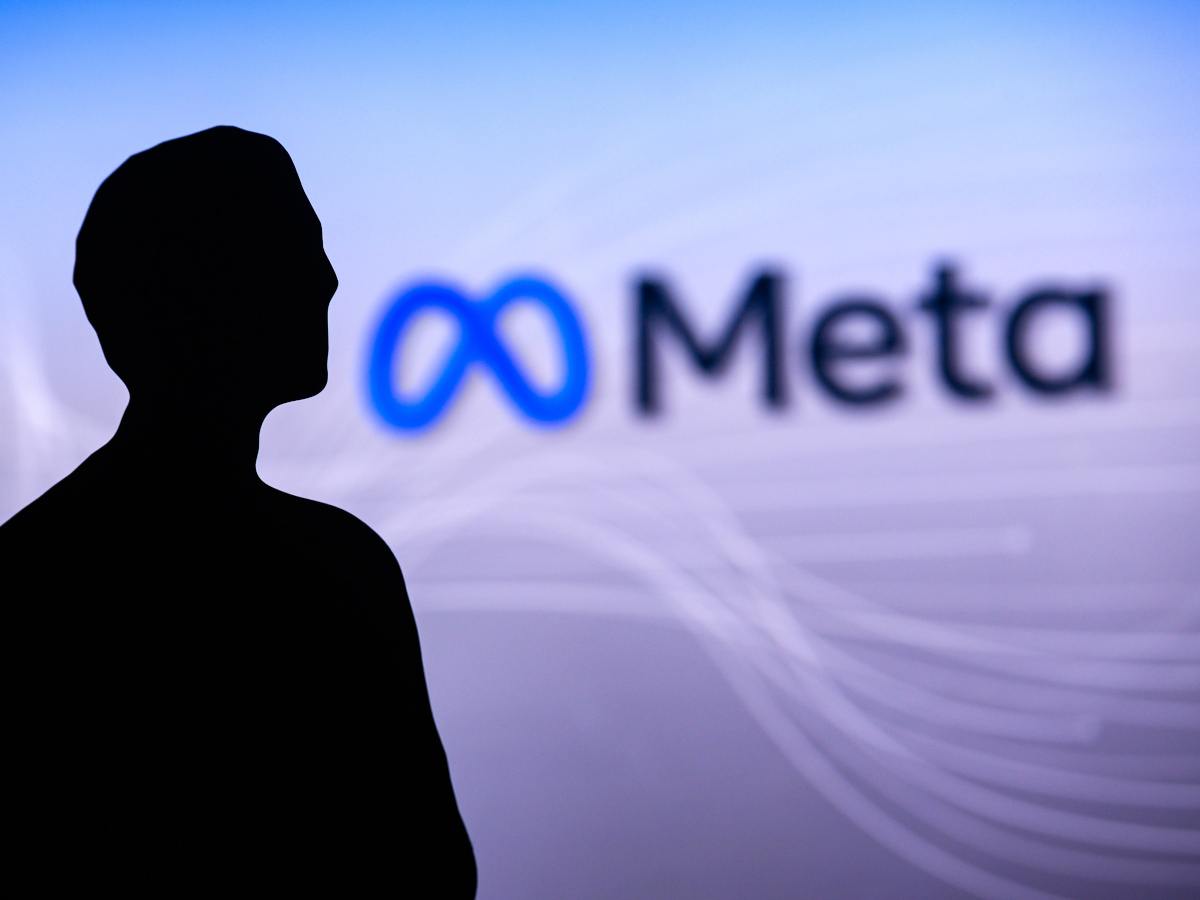 Meta logo in the background with the silhouette of Mark Zuckerberg in the foreground.