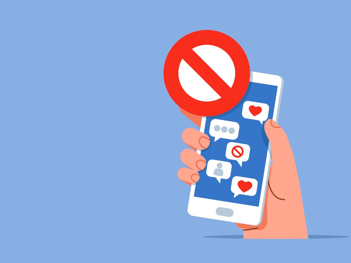 A cartoon hand holding a phone with social media icons and a ban sign over it