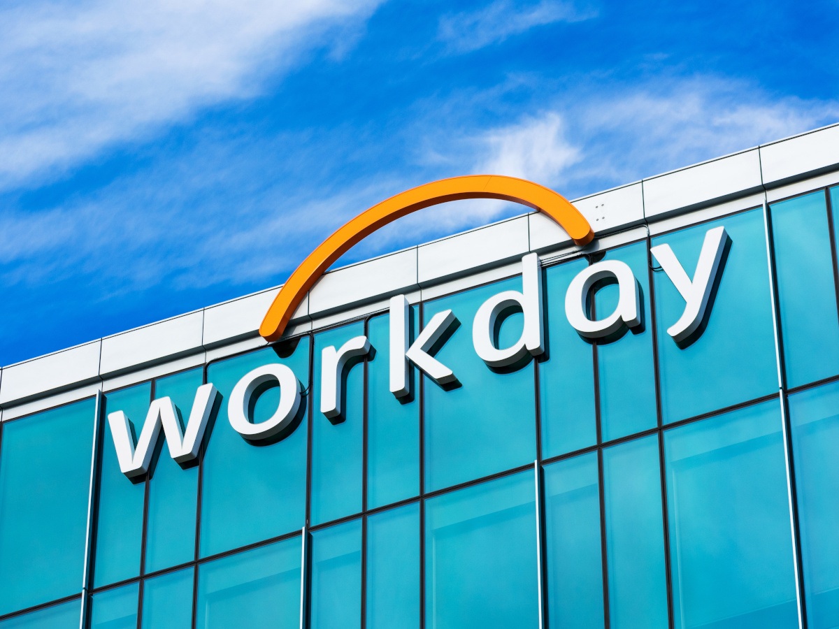 A picture of the Workday logo on the side of a building against a bright blue sky with wispy clouds.