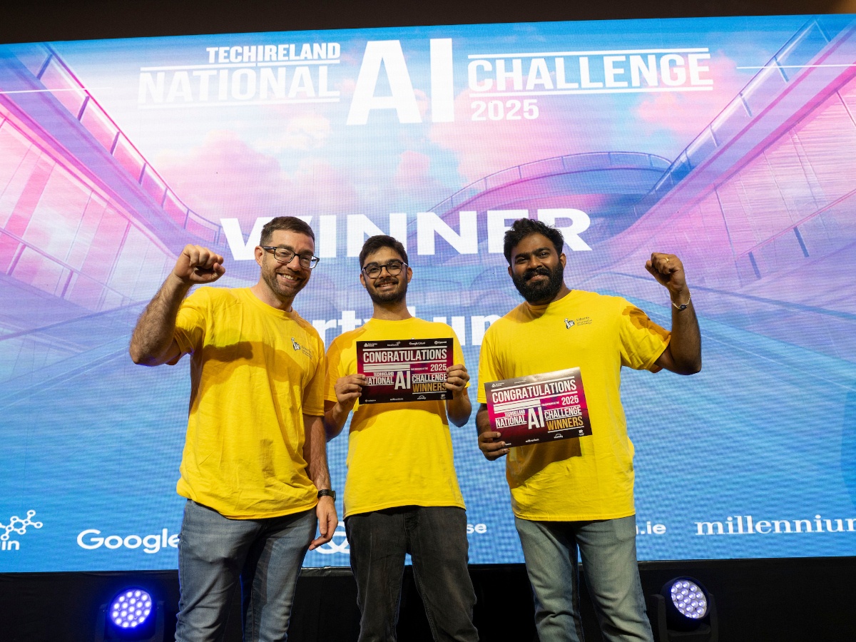 A picture of three men wearing yellow shirts celebrating at the 2025 TechIreland National AI Meet.