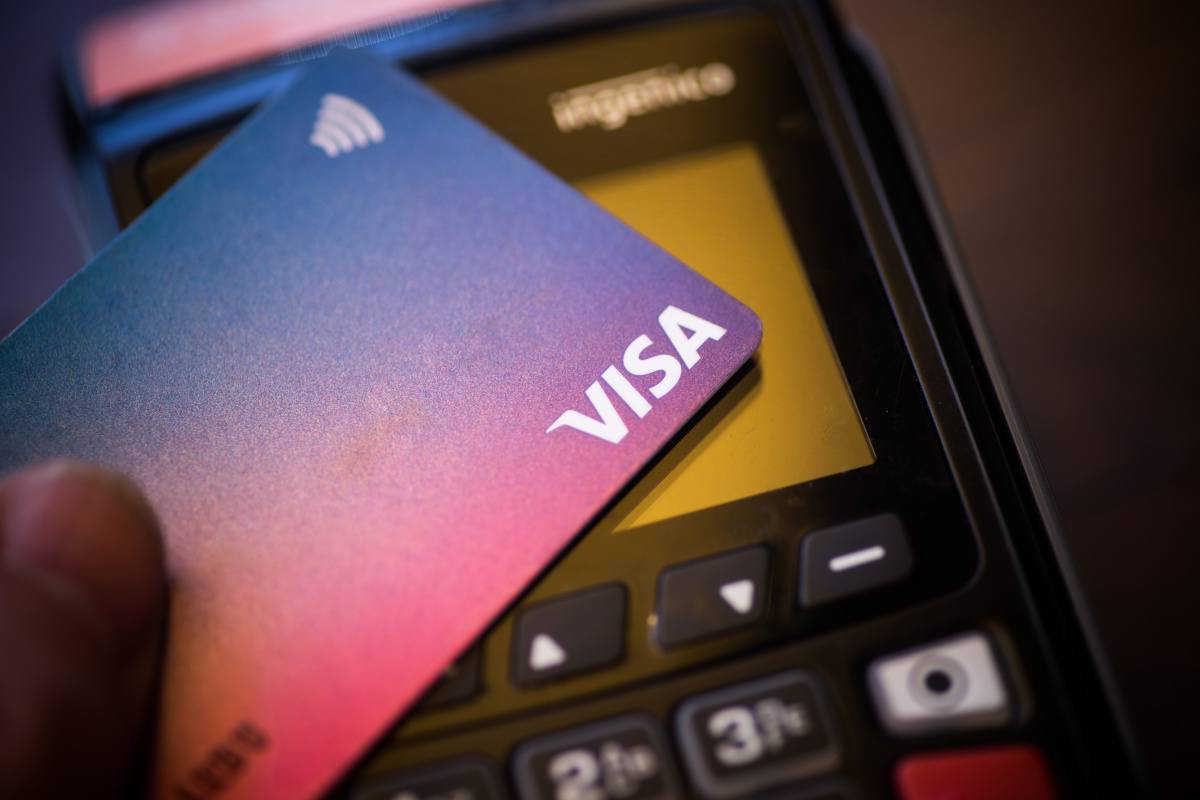 A Visa bank card being hovered over a payment terminal.