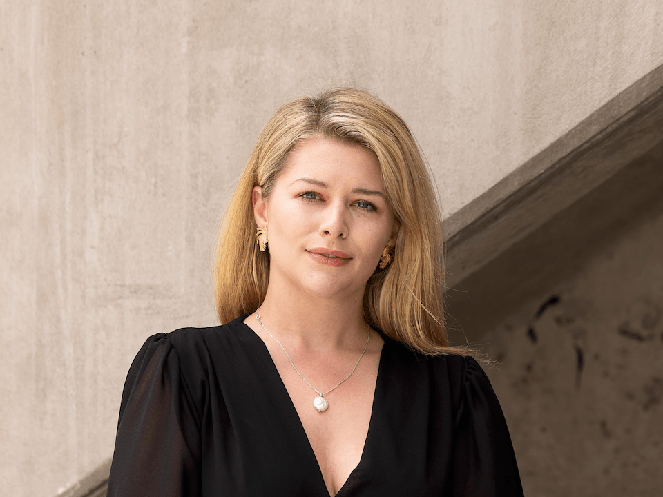 A woman with blonde hair, in a black dress.
