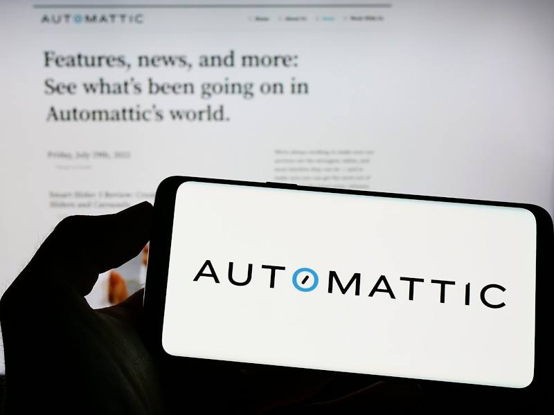 A smartphone and computer screen displaying information relating to Automattic. The company is feuding with WP Engine.