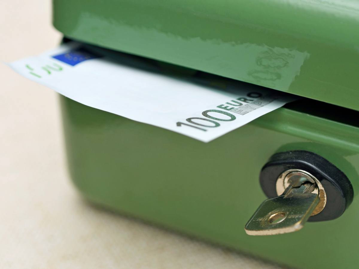 A euro note peaking out of a green metal cash box signifying the concept of unlocking cash.