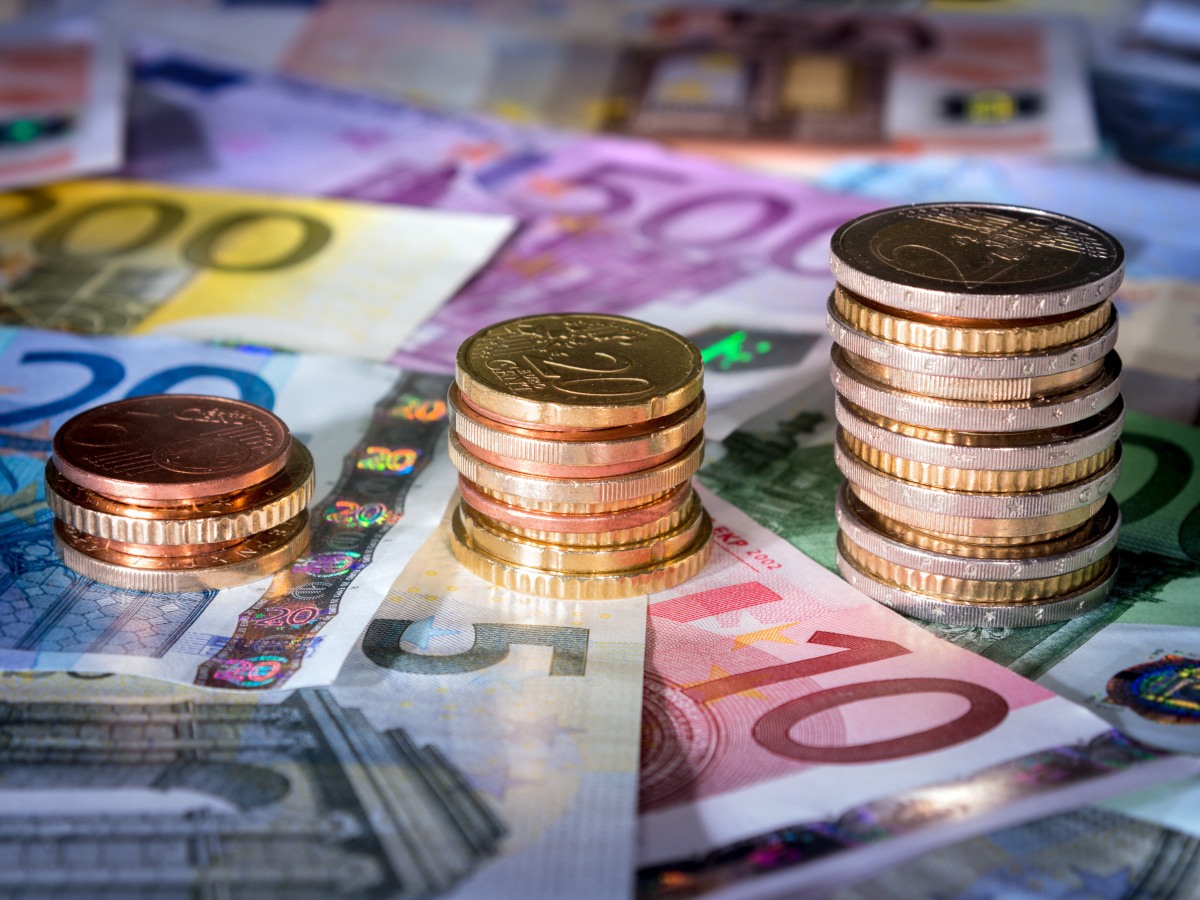 Euros stacked on top of European bank notes, for various amounts.