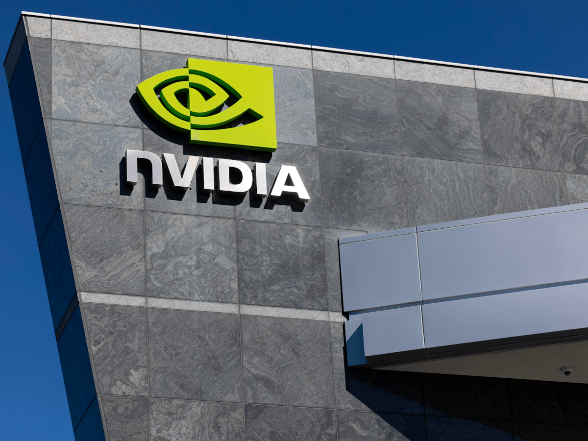 The Nvidia logo on a tall stone building, against a deep blue sky.