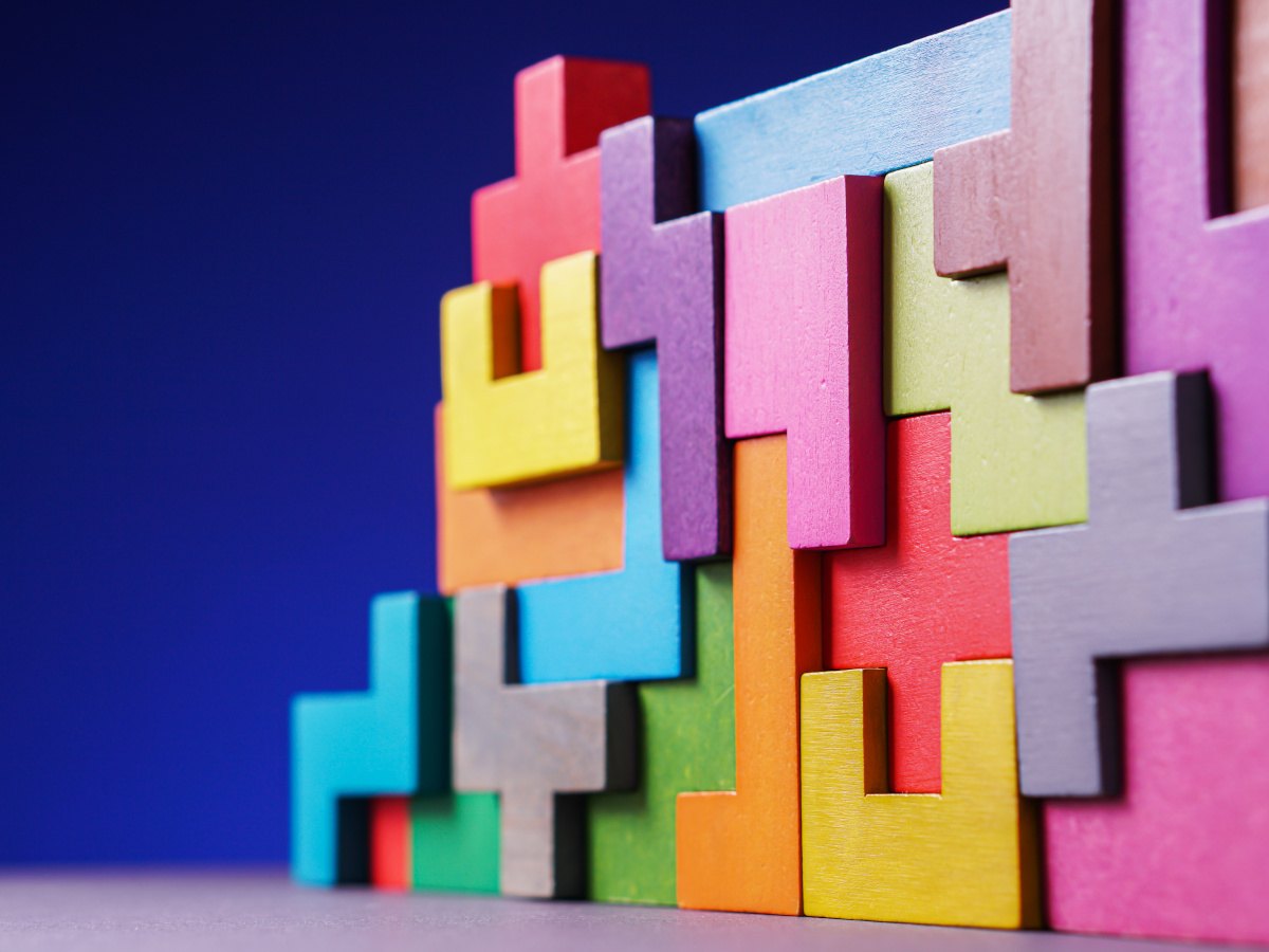 An arrangement of colourful wooden building blocks comprised of different shapes to build a structure.