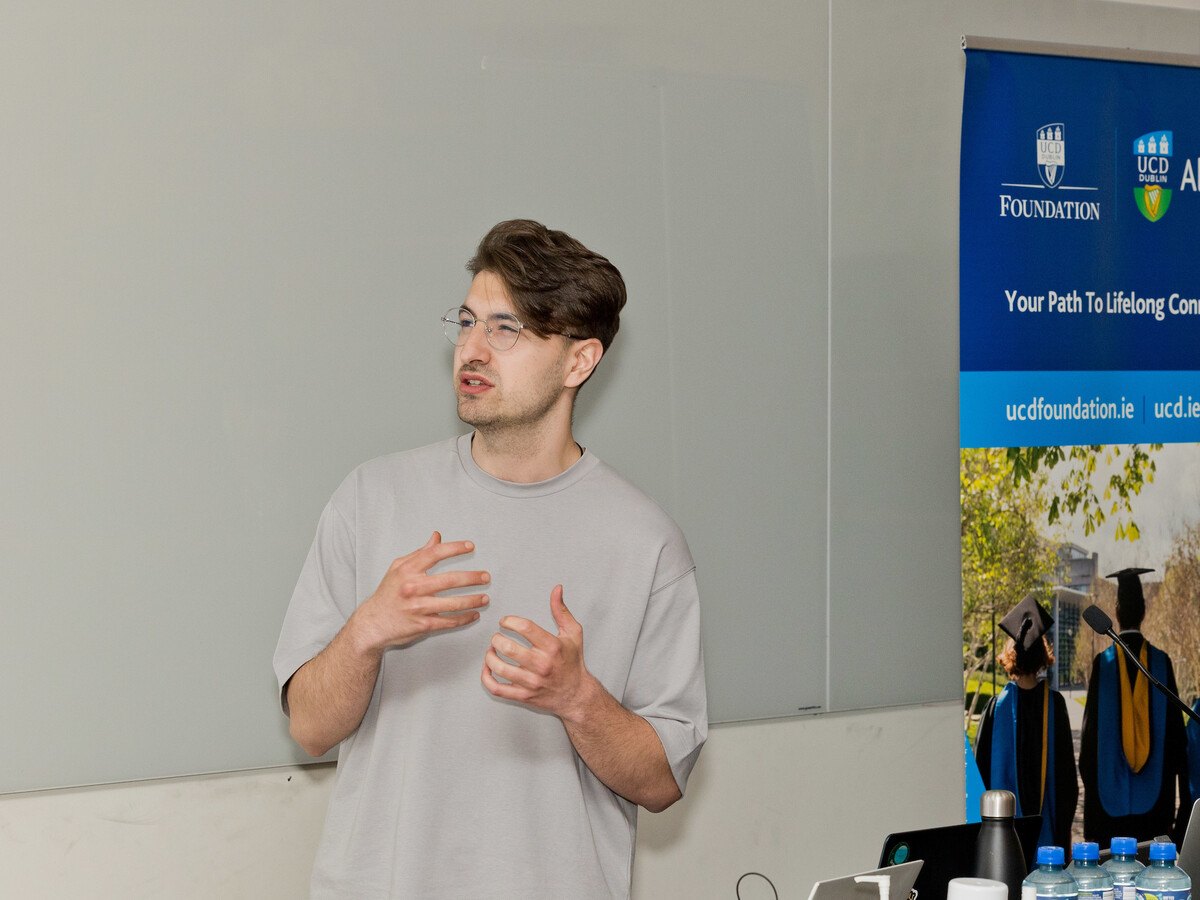 A man in a grey T shirt talking.