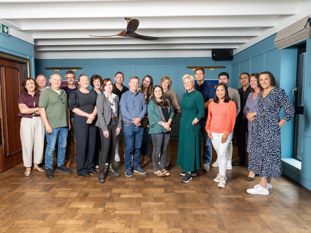 A group of people standing in a large room.
