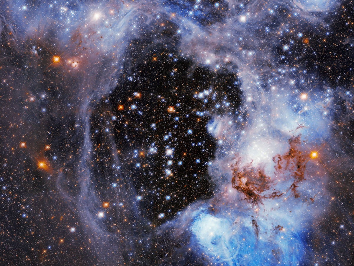 A picture of a large nebula in space with multiple bright stars around.