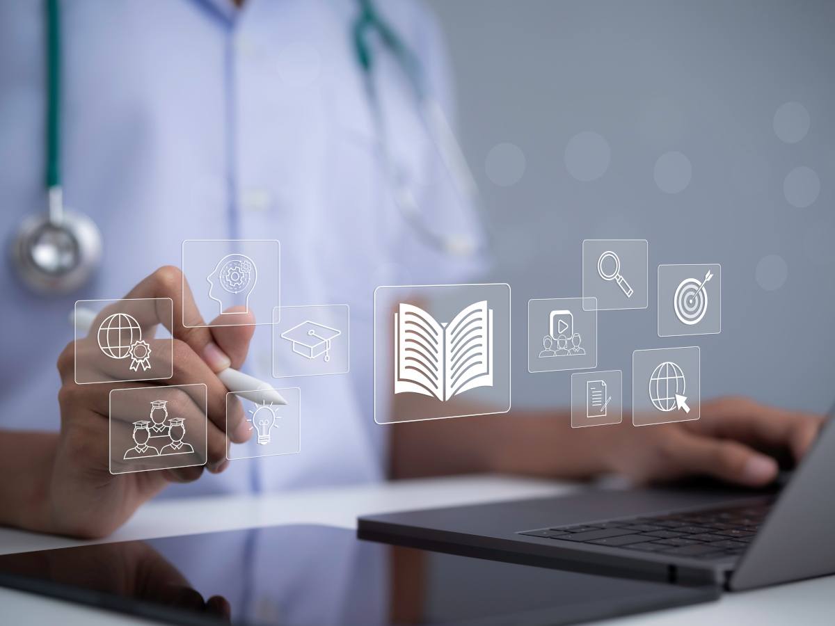 A medical professional working on a laptop surrounded by educational medical icons.