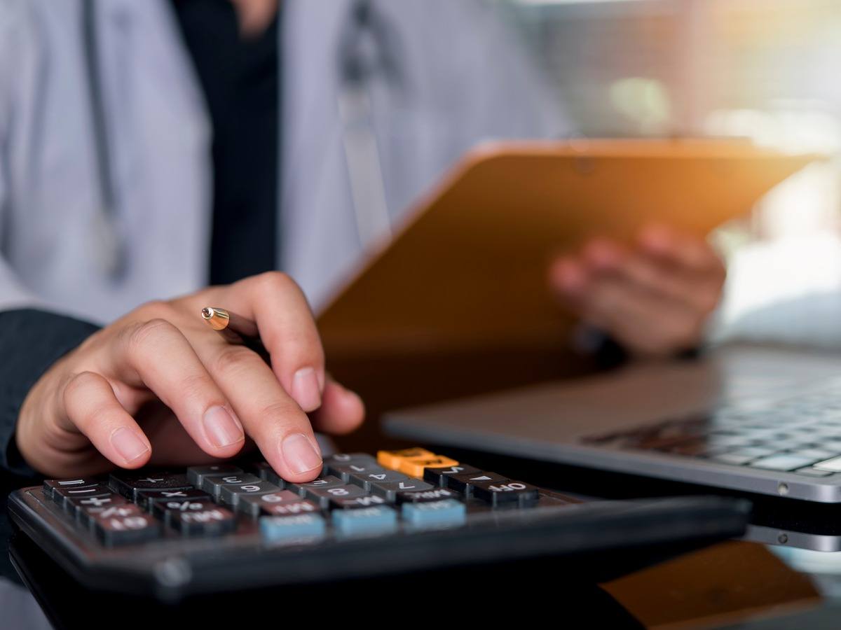 A man works using a calculator and a clipboard.