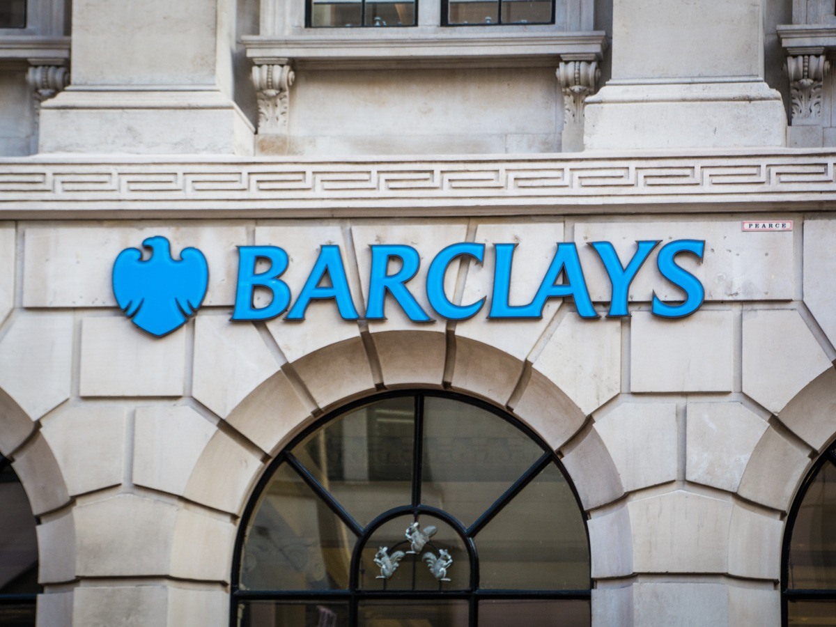The blue Barclays logo on a white stone brick building.