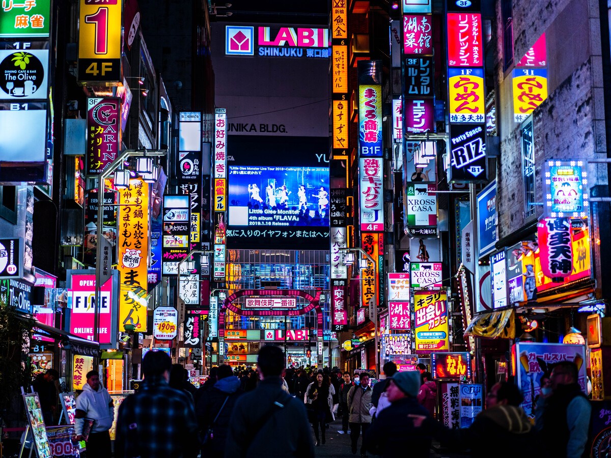 The streets of Tokyo at night, with bright signs and banners adorning the street.
